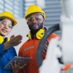 engineer cooperation male and female technician maintenance control relay robot arm system welding with tablet laptop to control quality operate process work heavy industry 4.0 manufacturing factory